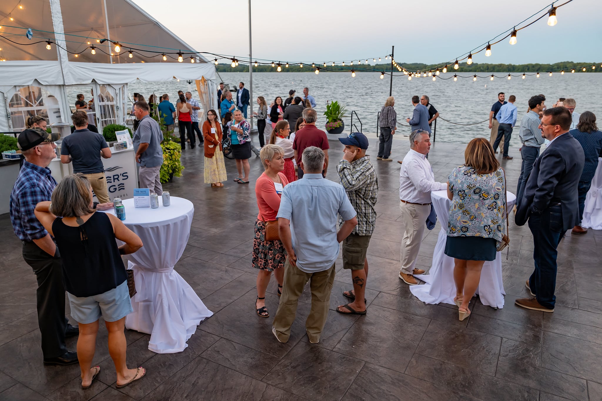 A large group of people standing around various cocktail tables at River's Edge event venue in Wrightsville, PA at the 2023 PA Taste event.