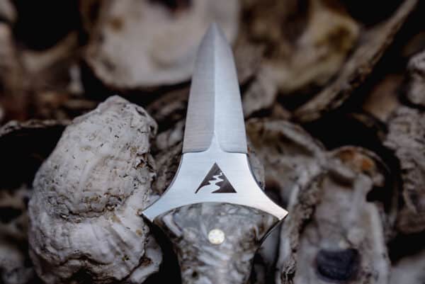 Oyster knife blade with Alliance logo carved into it.