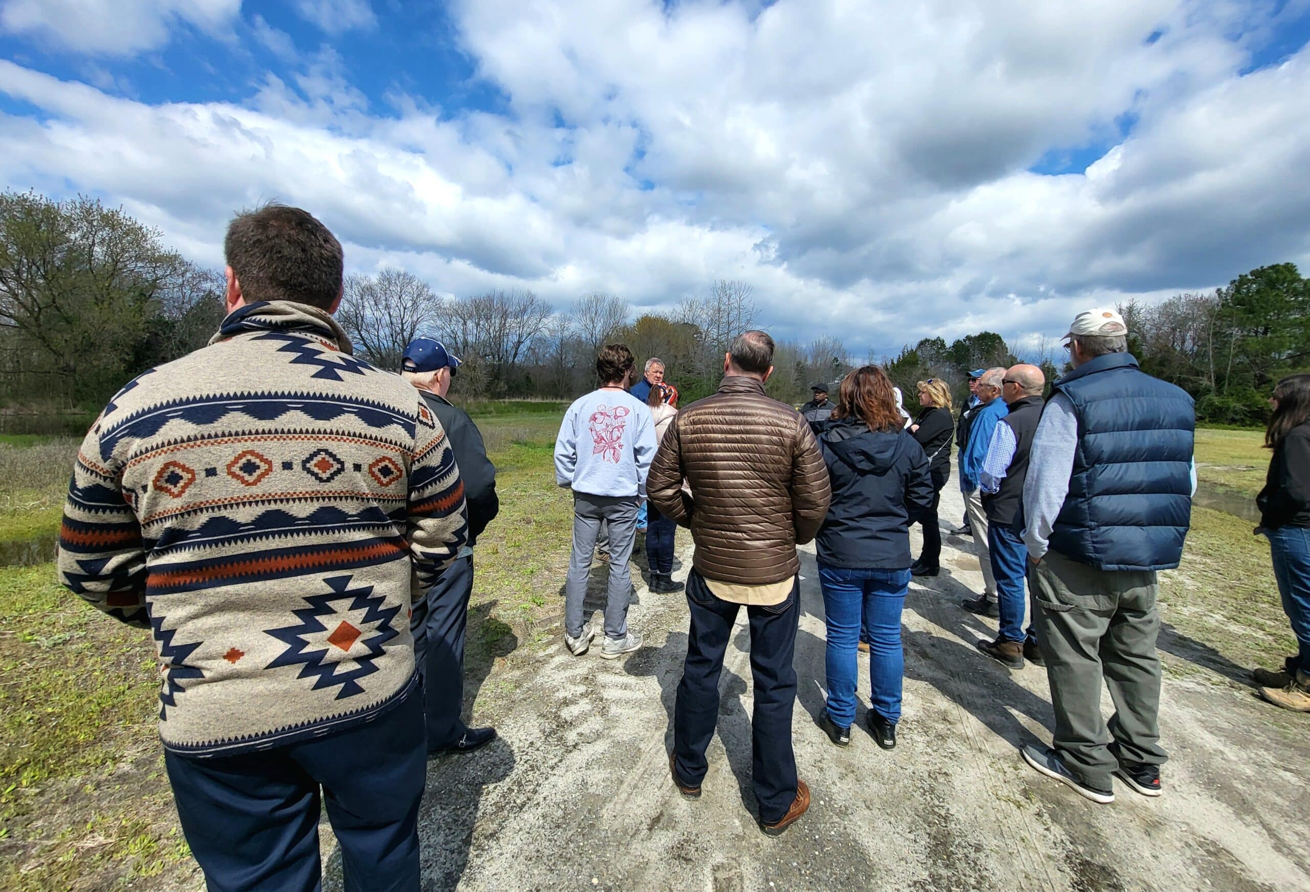 A group of people listen to someone speaking 