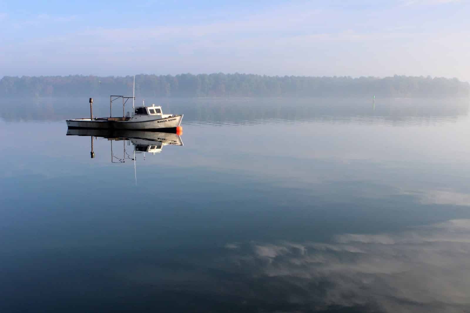 A boat on a large body of water on a foggy day