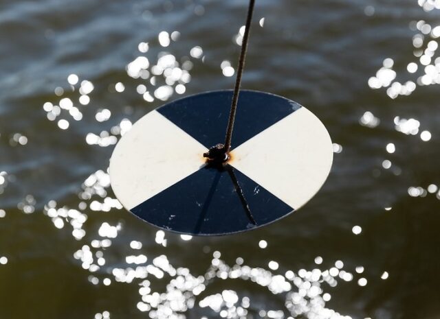 A close up of a black and white disk over water