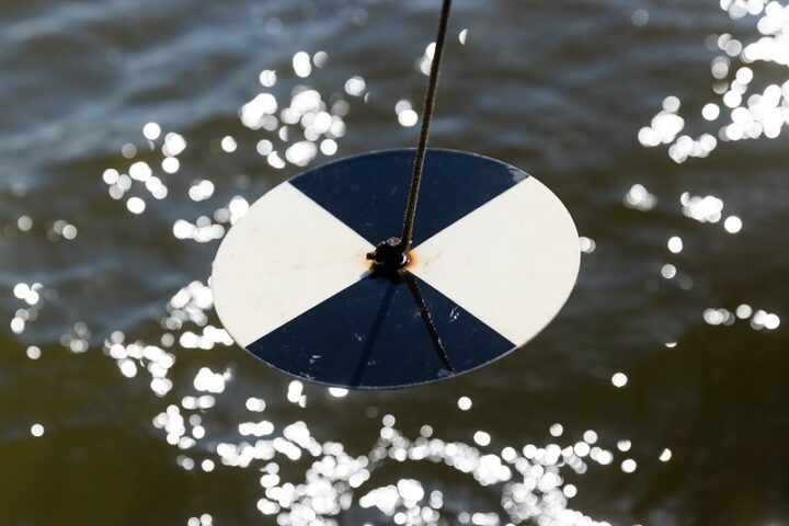 A close up of a black and white disk over water