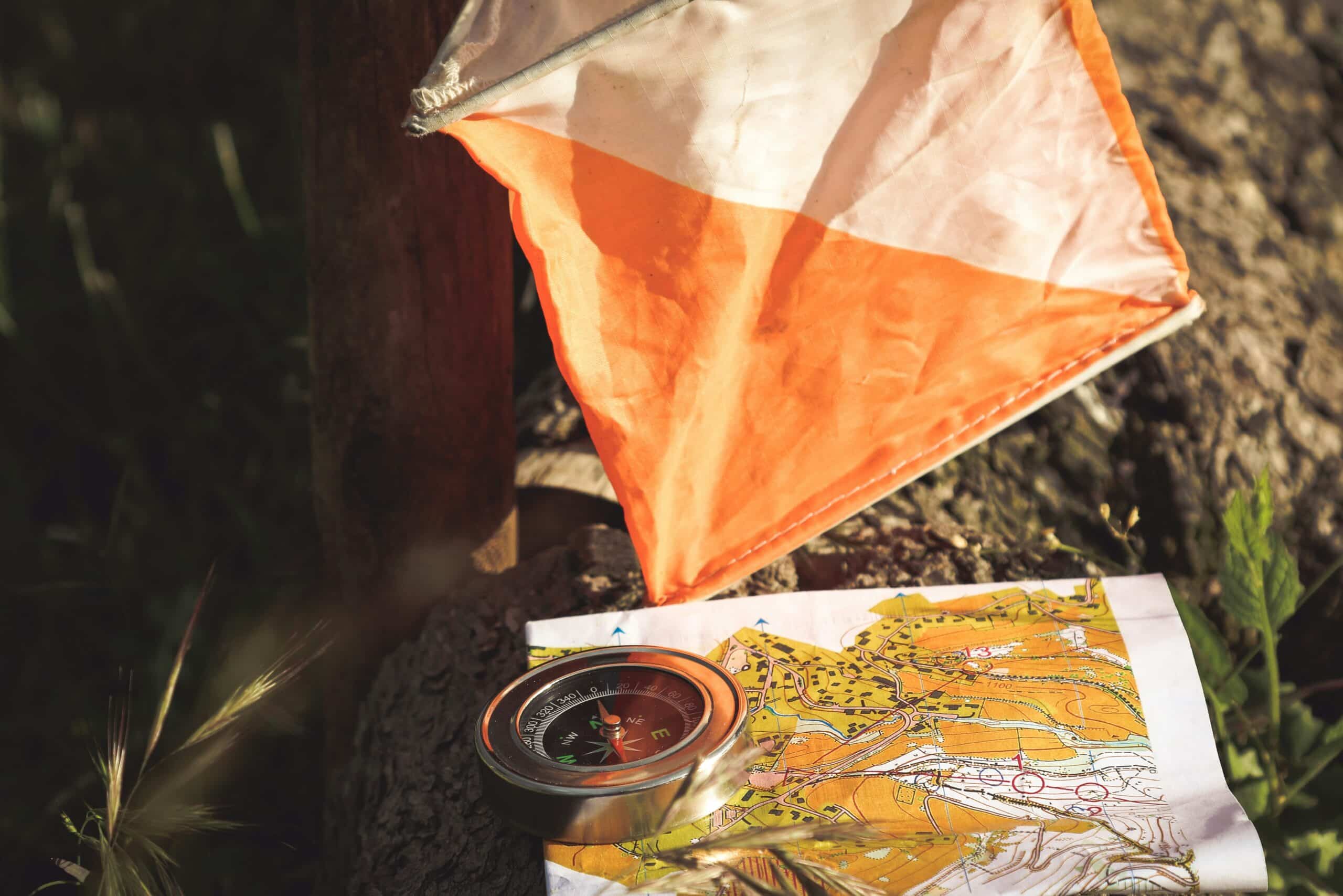 A compass and a map sitting on top of log