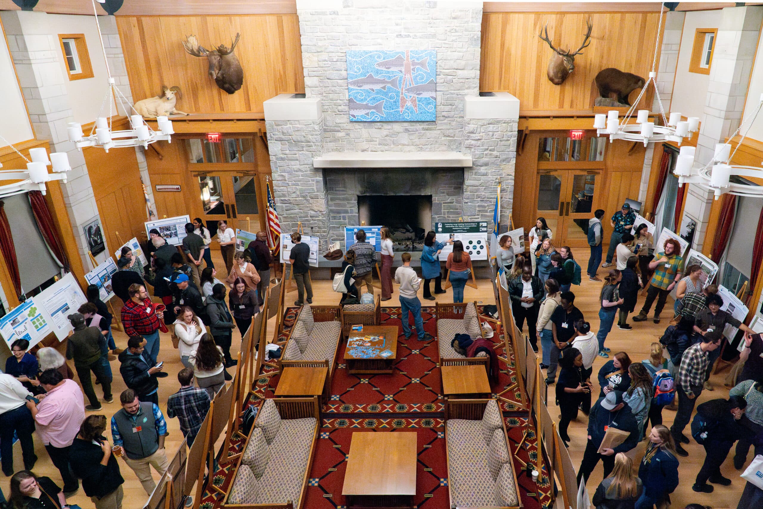 an overhead shot of a room full of people looking at poster displays