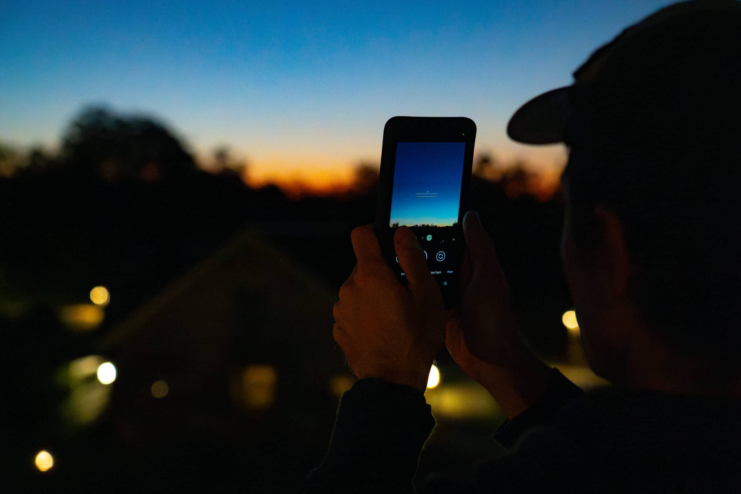 A person holding their phone up to the night sky