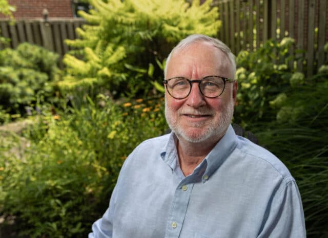 A person sitting in a yard full of plants