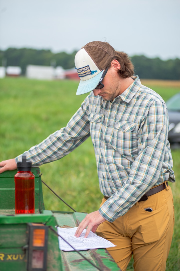 A person looks at project plans sitting on the tailgate of a utility vehicle