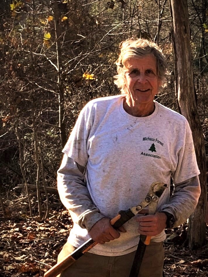 A person smiling while holding a pair of loppers.