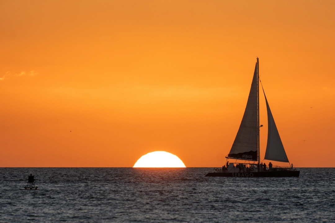 A sailboat in front of an ocean sunset